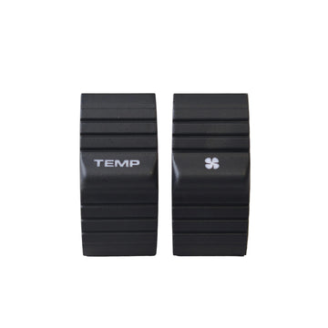 Two black ribbed electronic control modules labeled TEMP and with a small four-leaf symbol, standing upright on a light gray surface.